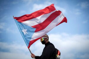 Bad Bunny waves a Puerto Rican flag in San Juan, Puerto Rico on July 17, 2019.