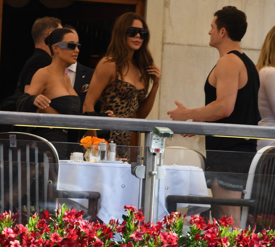 Kim Kardashian and Khloe Kardashian at a table outdoors.